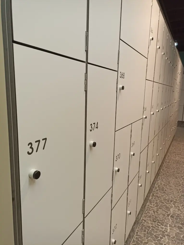 Casiers blancs sur trois hauteurs, numéros gravés dans les portes et serrures électroniques à bouton