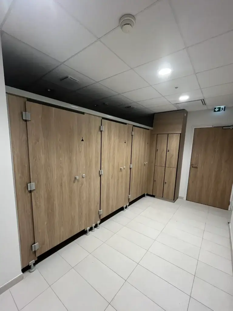 Trois cabines de déshabillage et des casiers en décor chêne dans l'espace spa du centre Aquavithal